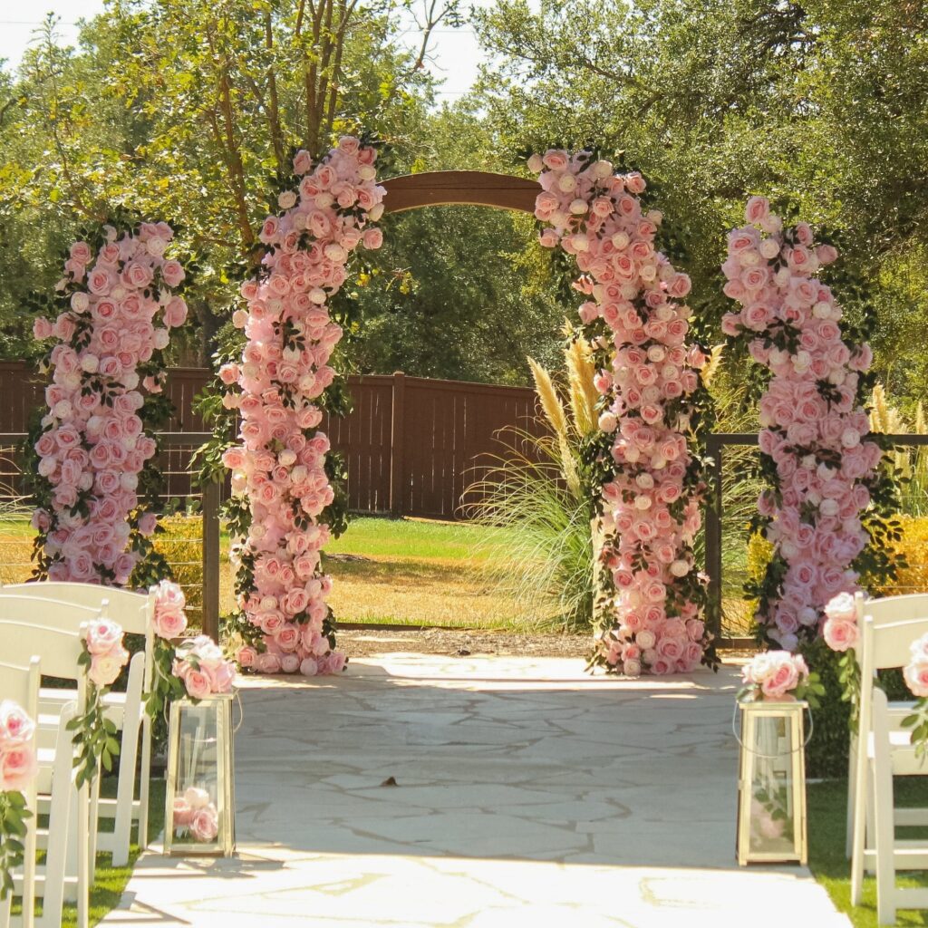 Wooden Floral Arch with white rose and peony at open field surrounded by trees