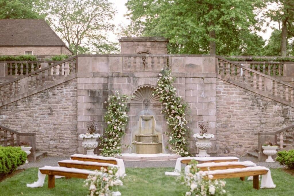 Simple Floral Altar With Wooden Bench and Floral Arch