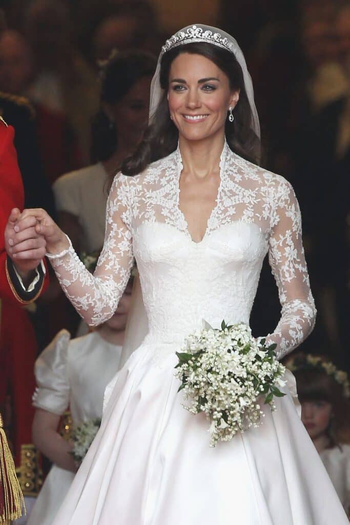 Beautiful Kate Middleton in white dress holding Lily Of The Valley bouquet