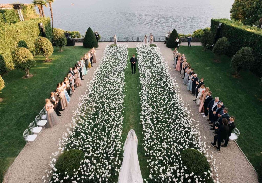 Floral Aisle Runner with sprinkled floral petals and Bridesmaids and Groomsmen standing on the side