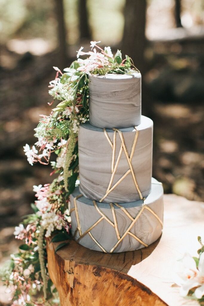 3-Tiered Wedding cake with marble texture and gold geometric lines and added floral decoration