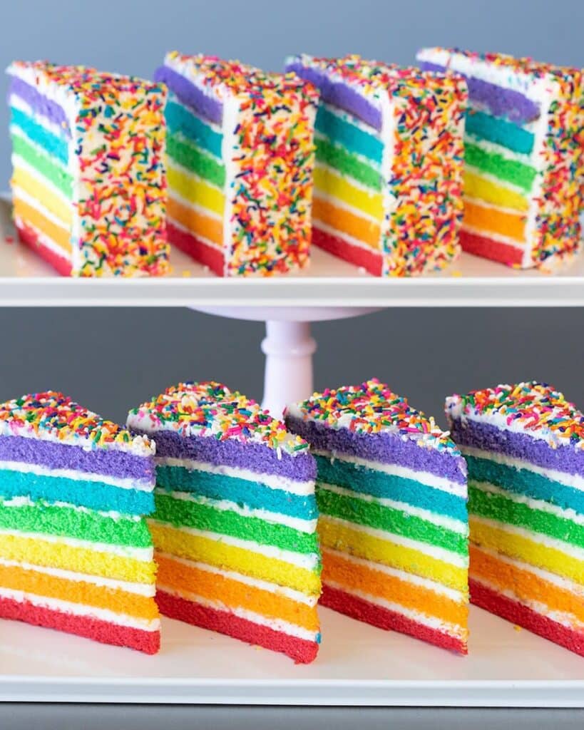 Rainbow Cake with white icing and colorful choco sprinkles