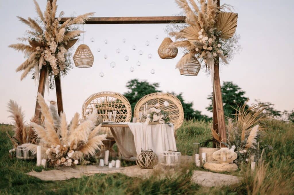 Boho Wedding Style Venue with stunning Greenery Boho Wooden Arch, pampas decoration and aesthetic pastel blankets