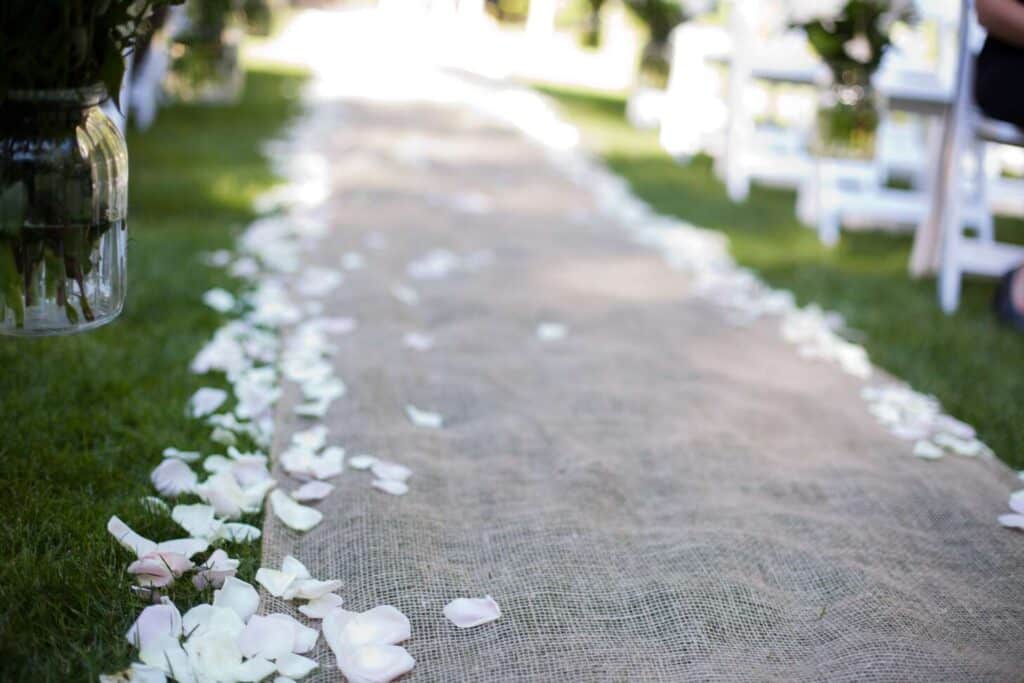 Rose petals sprinkled on wedding aisle runner