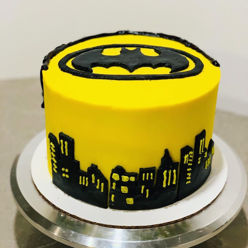 Batman Birthday Cake with yellow frosting, edible fondant Batman Logo and Gotham cityscape